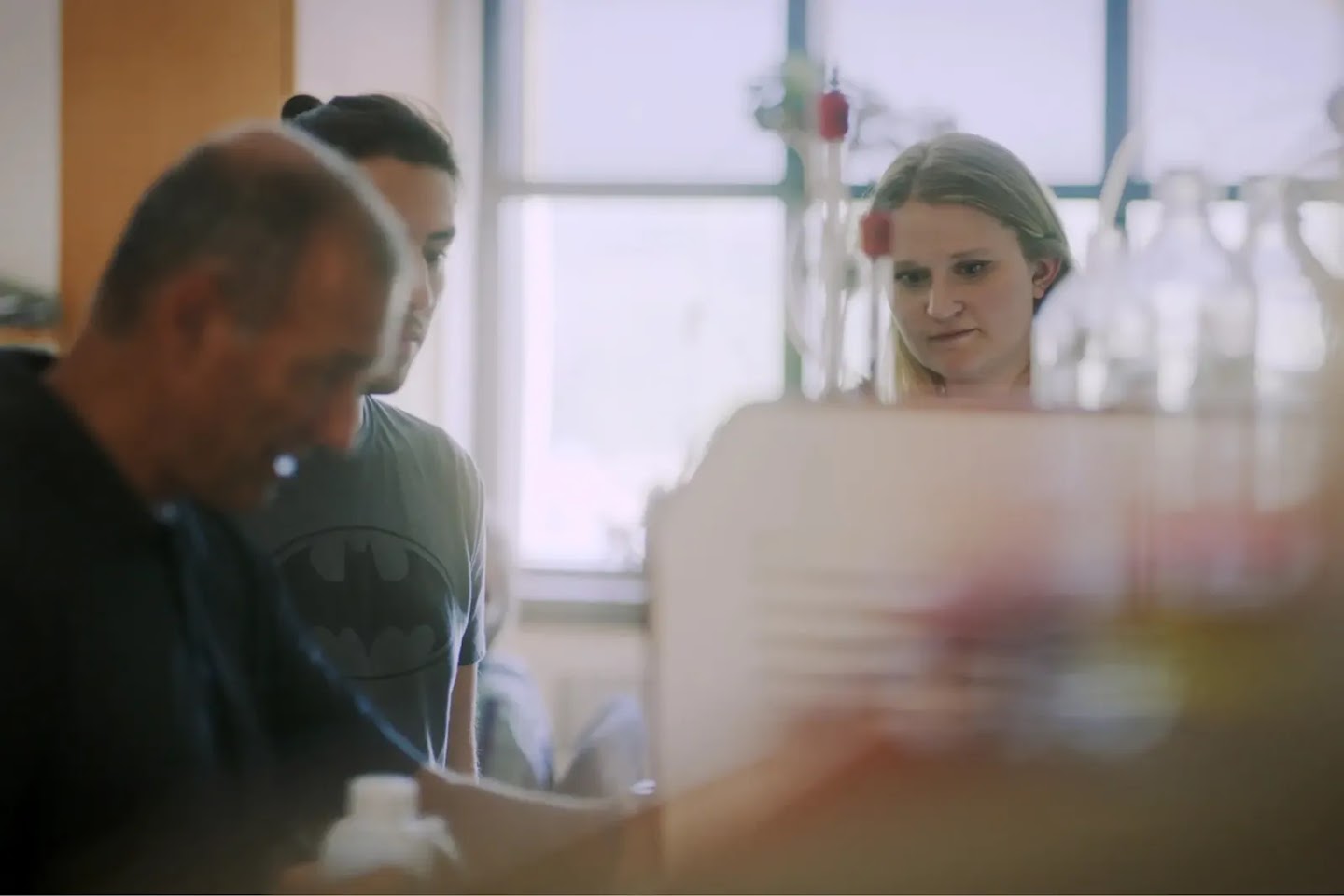 A group of three biochemists in a laboratory.