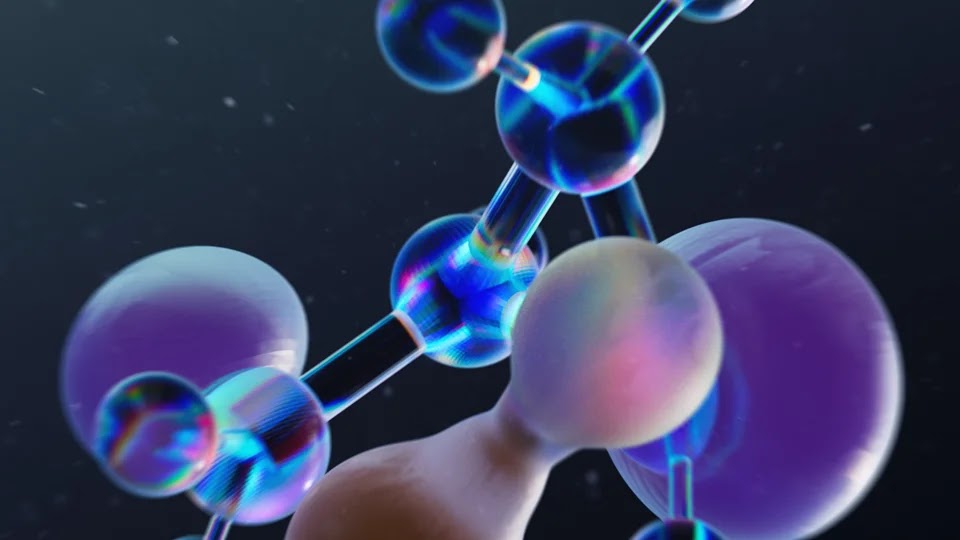A highly detailed, iridescent 3D molecular structure consisting of spheres and connecting rods, floating in a dark space filled with tiny, floating particles.