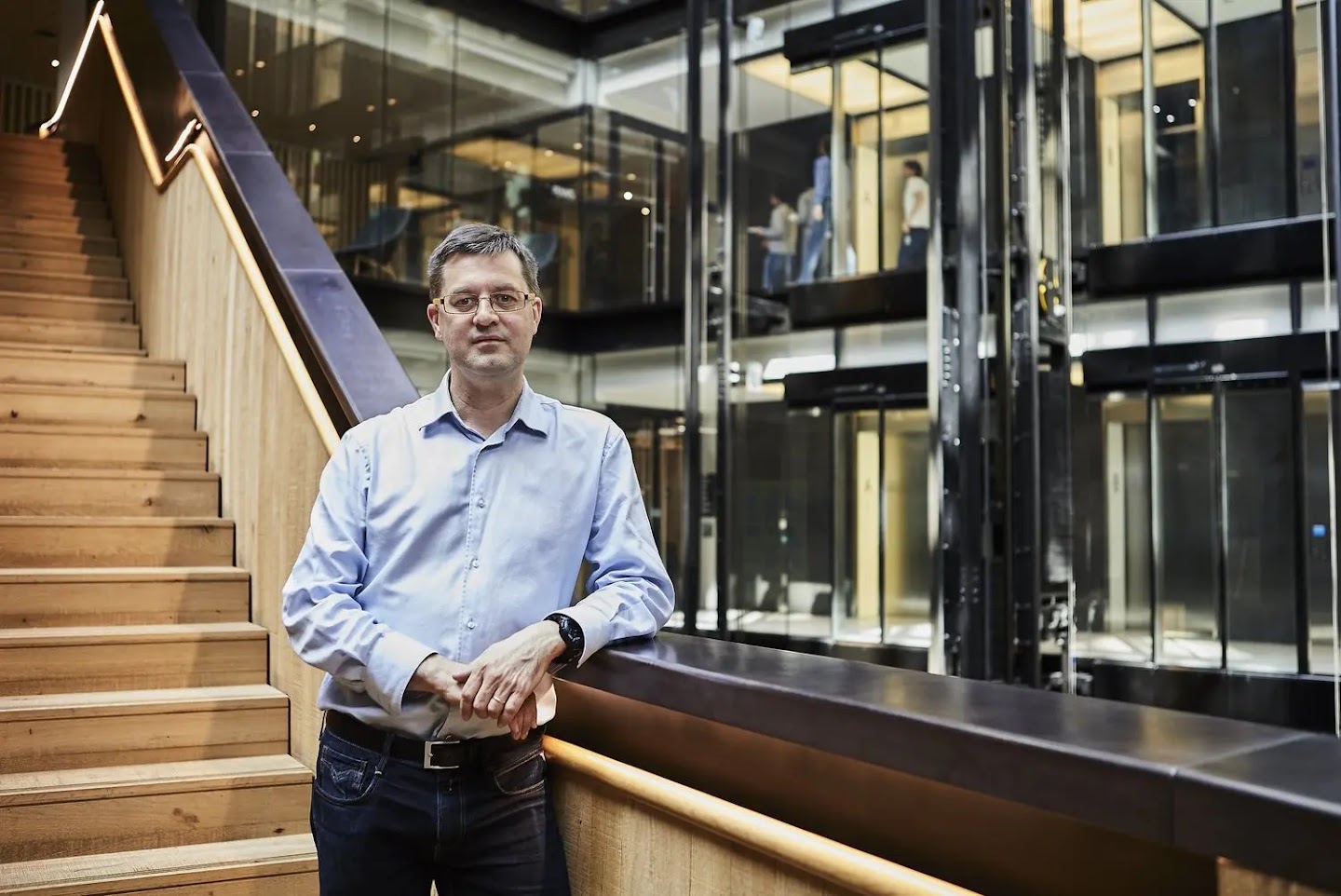 Rémi Munos, a middle aged white man, leans against a staircase in the Google offices, he's looking straight to camera.