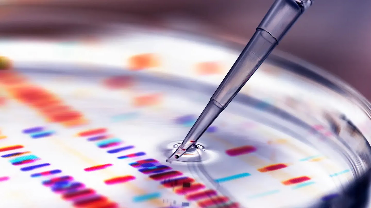 A pipette tip dipping into liquid over a colorful DNA gel electrophoresis pattern.