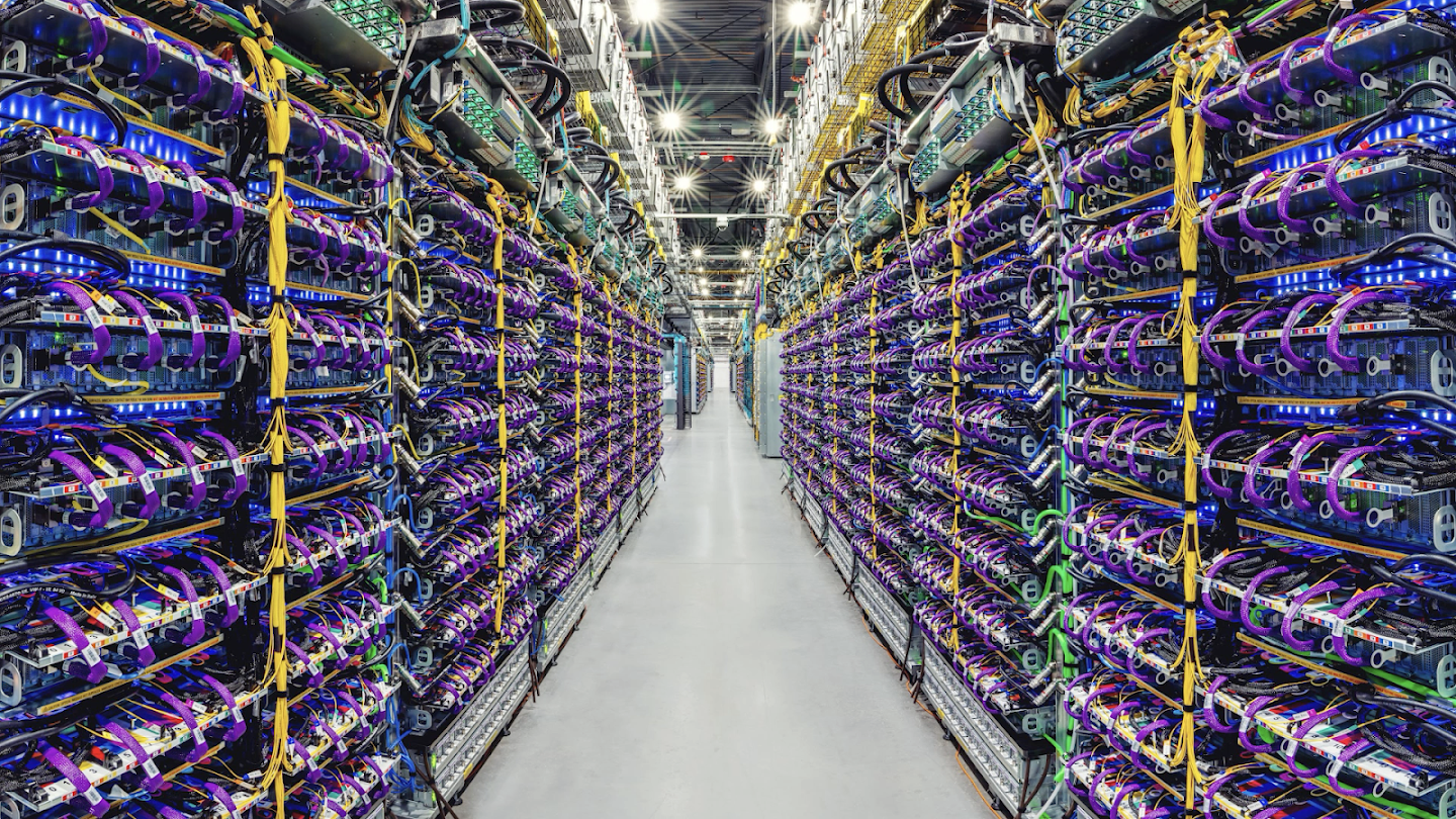 Photograph of a row of Cloud TPU v5p AI accelerator supercomputers in a Google data center